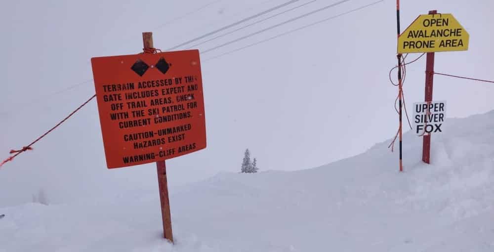 Signs warning ofthe dangers of skiing off piste in cliffed out areas. Snowbird Ski Area, Utah, USA